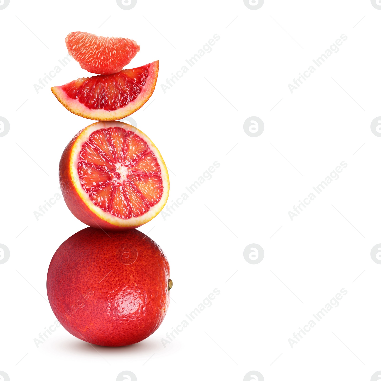 Image of Stacked cut and whole red oranges on white background