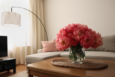 Beautiful pink peonies in vase on table at home, space for text. Interior design