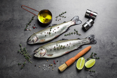 Photo of Flat lay composition with raw cutthroat trout fish on grey table