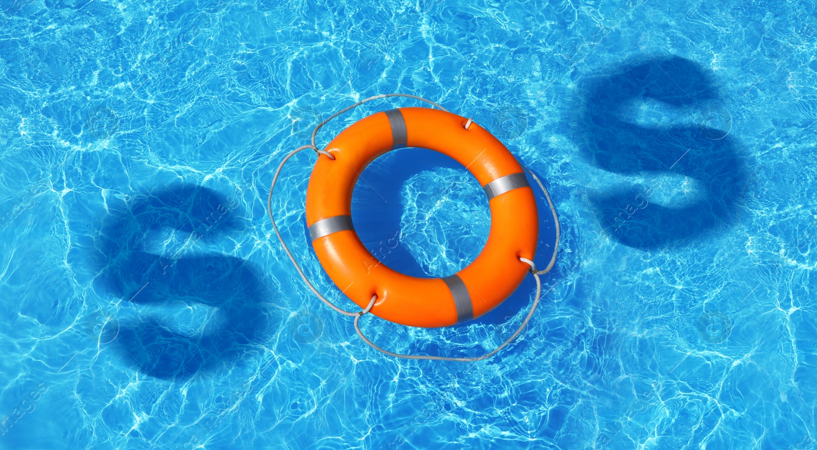 Image of SOS message made from lifebuoy and shadow of letters in pool, top view