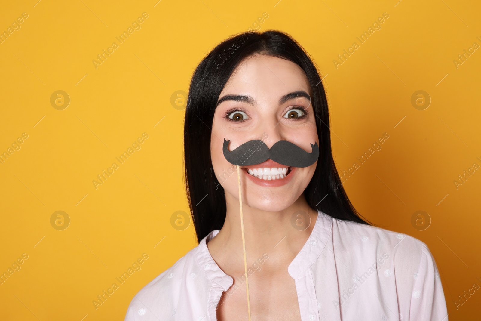 Photo of Funny woman with fake mustache on yellow background