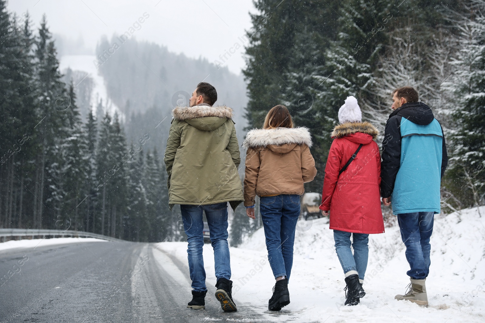 Photo of Group of friends walking near snowy forest. Winter vacation