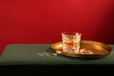 Photo of Glass of alcohol drink and shards of broken mirror on soft surface, space for text