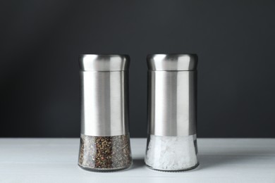 Photo of Salt and pepper shakers on white table, closeup
