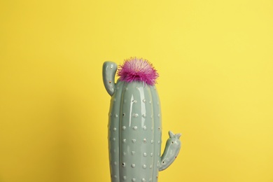 Photo of Trendy cactus shaped ceramic vase with flower on color background