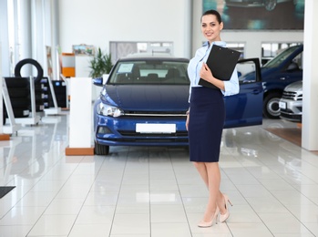 Photo of Portrait of young saleswoman in car dealership
