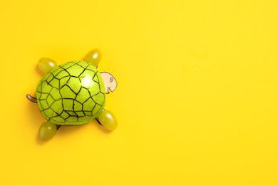 Funny turtle made of grapes on color background, top view. Space for text