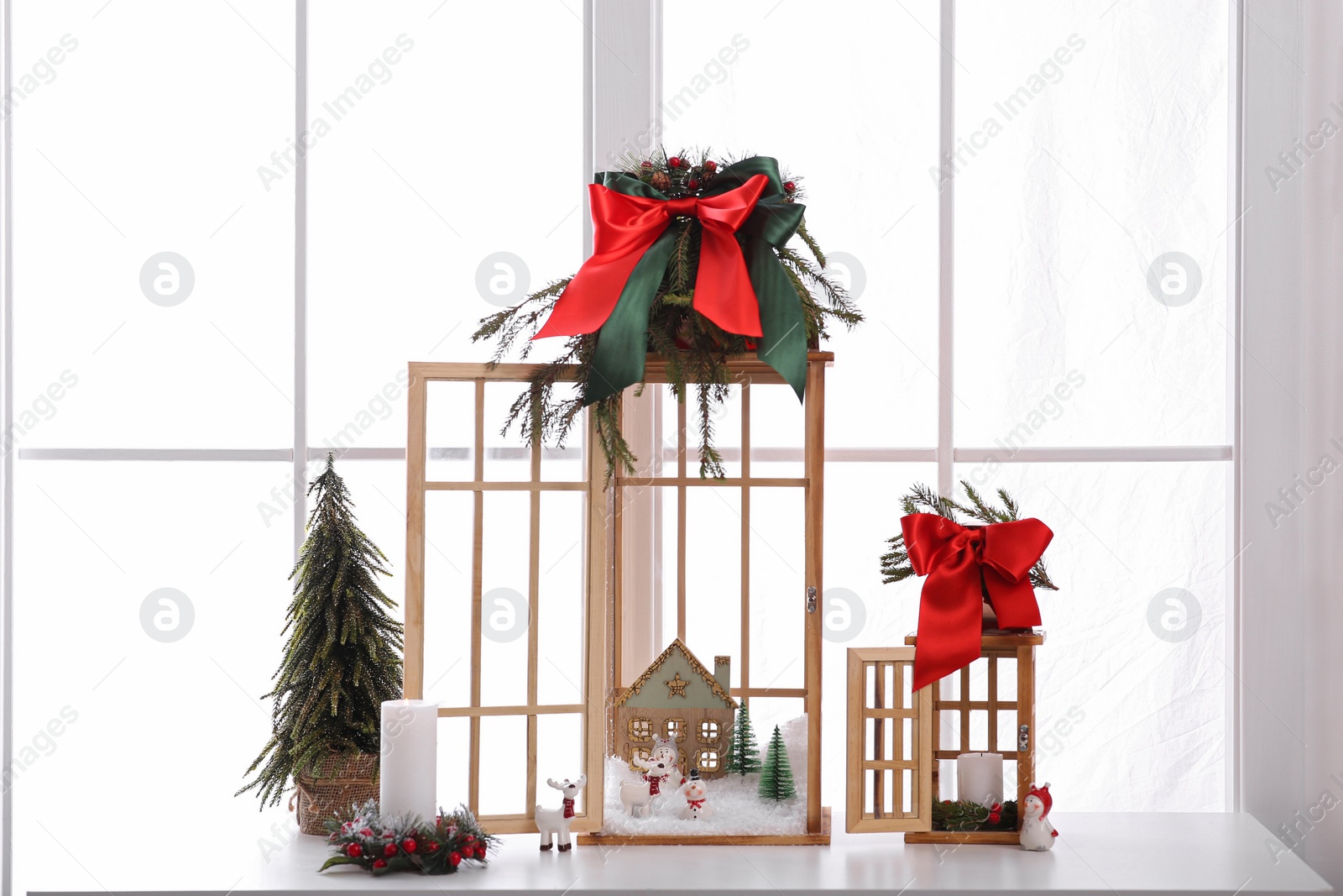 Photo of Vintage wooden lanterns with beautiful Christmas decor on window sill indoors