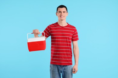 Man with cool box on light blue background