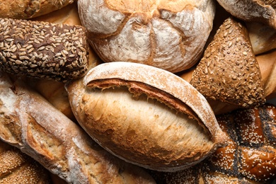 Photo of Different kinds of fresh bread as background, top view