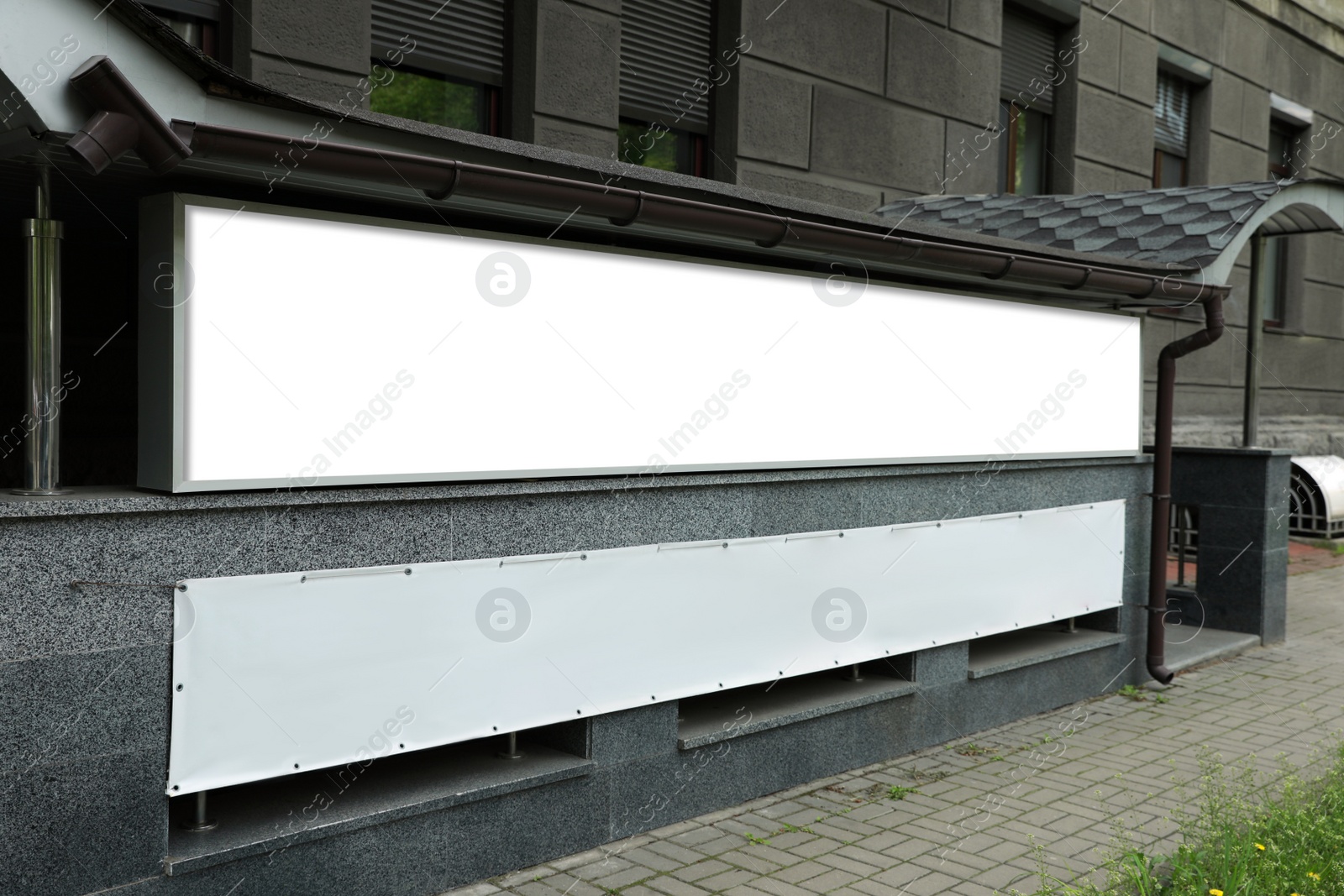 Photo of Blank banner on building facade outdoors. Advertising board design