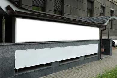 Blank banner on building facade outdoors. Advertising board design