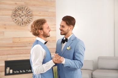 Photo of Happy newlywed gay couple dancing at home