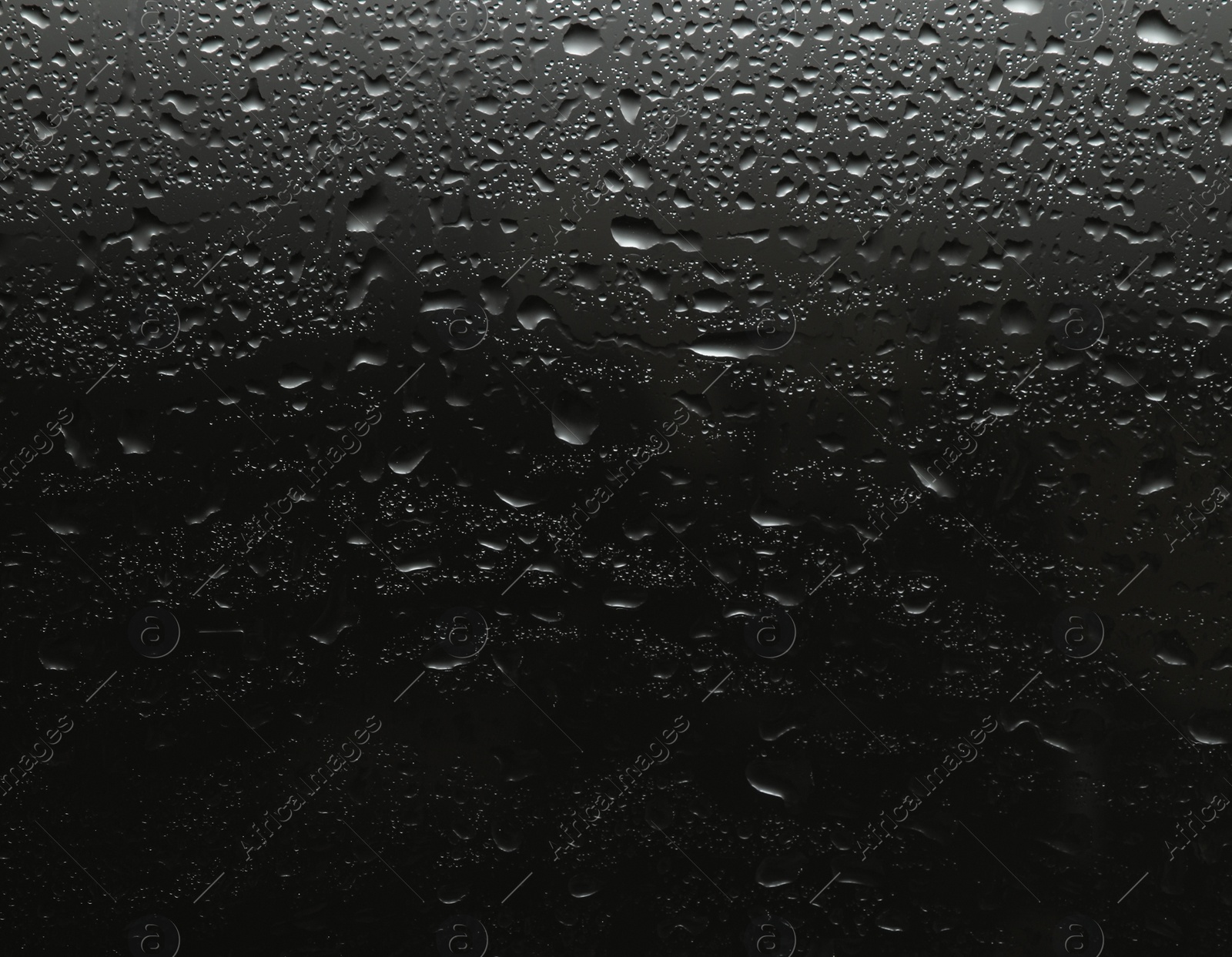 Photo of Rain drops on glass against black background