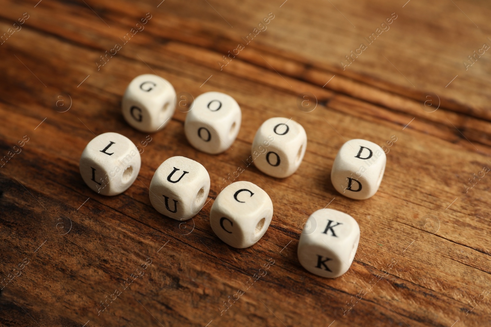 Photo of Cubes with phrase GOOD LUCK on wooden table, closeup