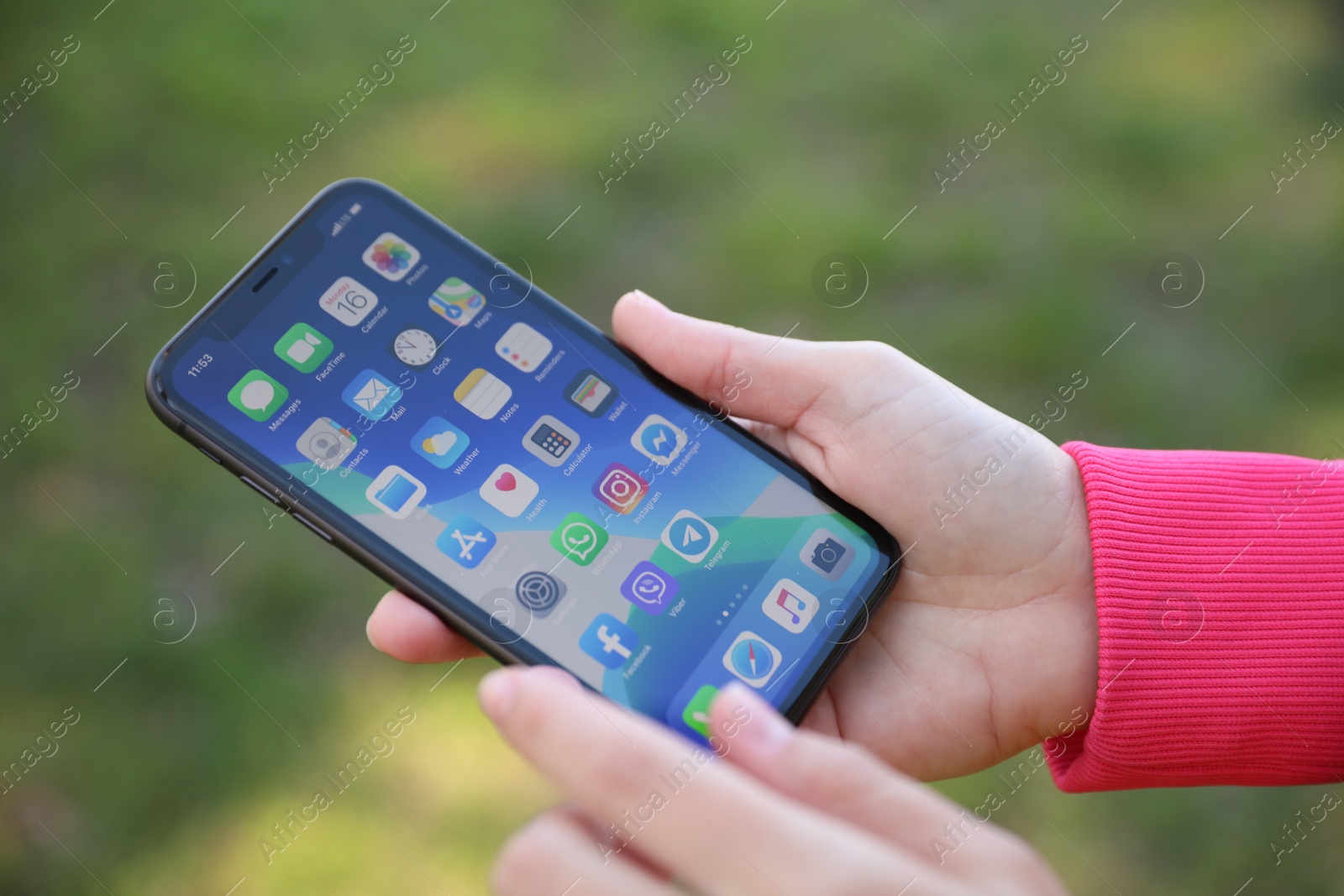 Photo of MYKOLAIV, UKRAINE - MARCH 16, 2020: Woman holding iPhone 11 with home screen outdoors, closeup
