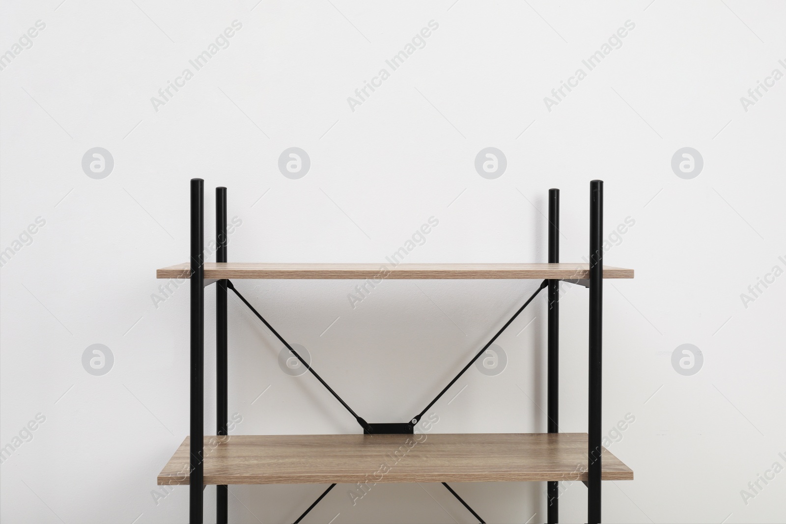 Photo of Modern wooden shelves unit at light wall