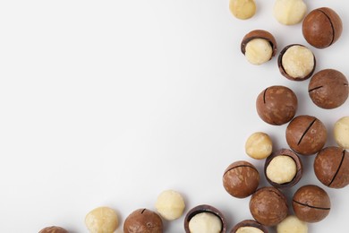 Photo of Tasty Macadamia nuts on white background, flat lay. Space for text