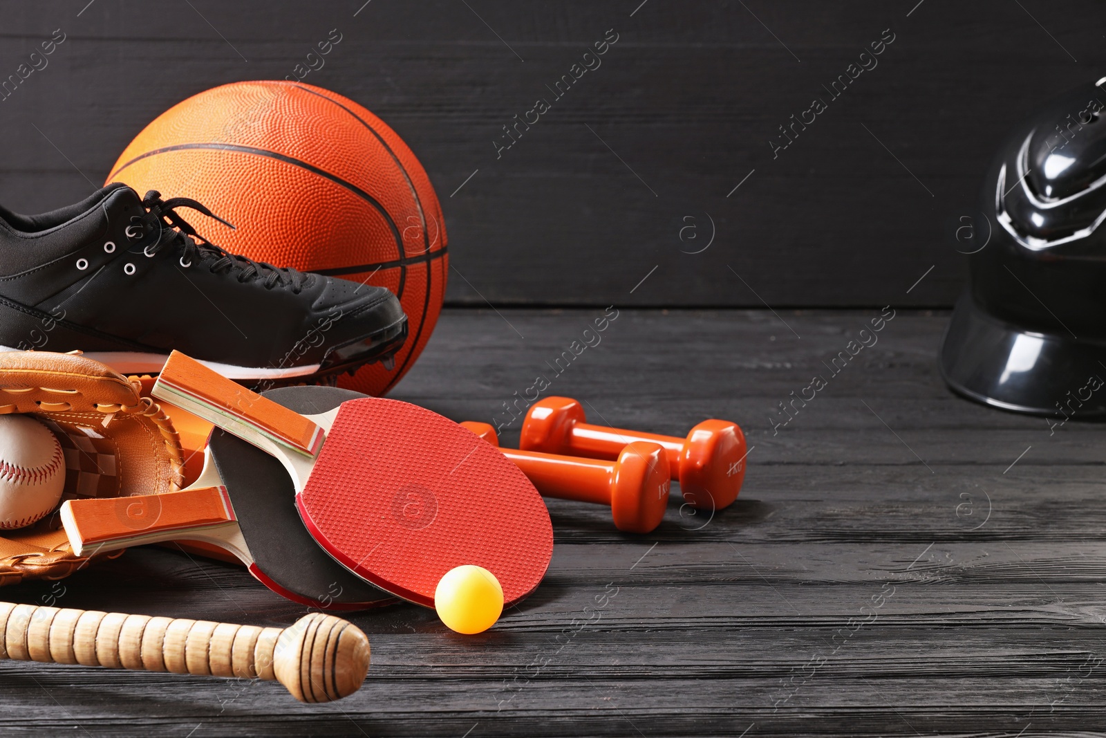 Photo of Many different sports equipment on dark grey wooden table