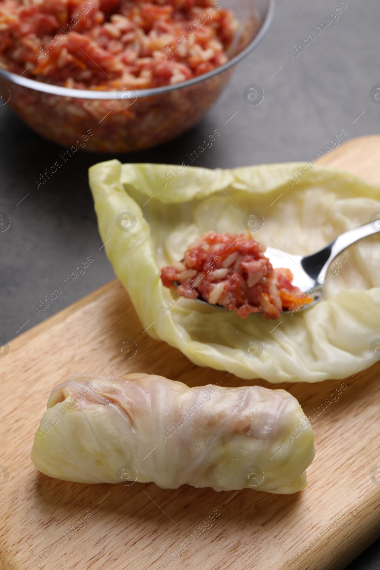 Photo of Preparing stuffed cabbage rolls on table, closeup