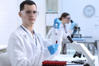 Photo of Scientist dripping sample into test tube in laboratory