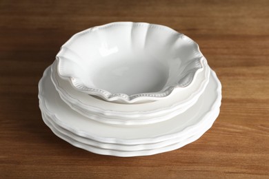 Stack of ceramic dishware on wooden table, closeup