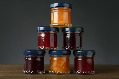 Photo of Jars of different jams on wooden table