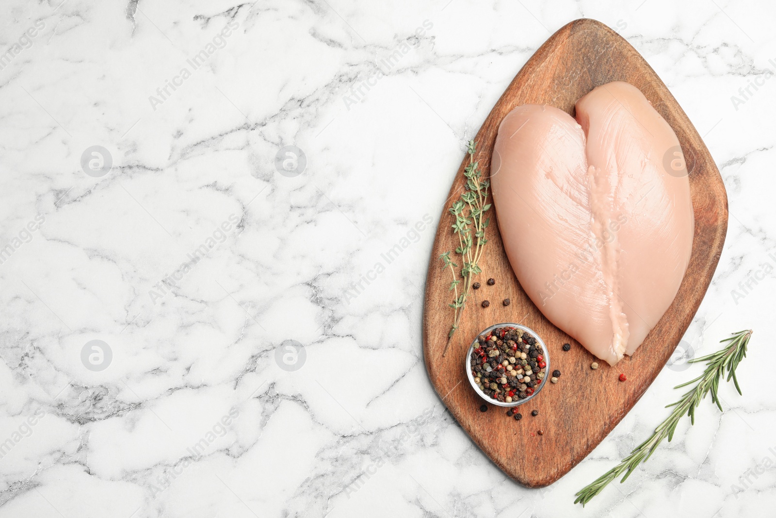 Photo of Fresh chicken meat and seasonings on marble table, flat lay. Space for text