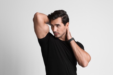 Portrait of handsome young man in black t-shirt on grey background