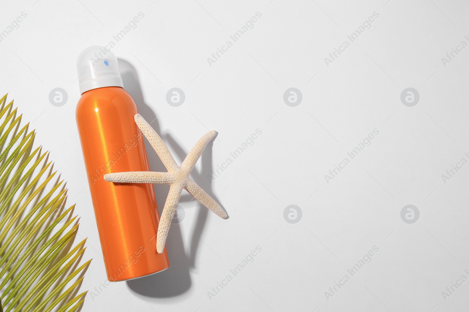 Photo of Sunscreen, starfish and tropical leaf on white background, flat lay and space for text. Sun protection care