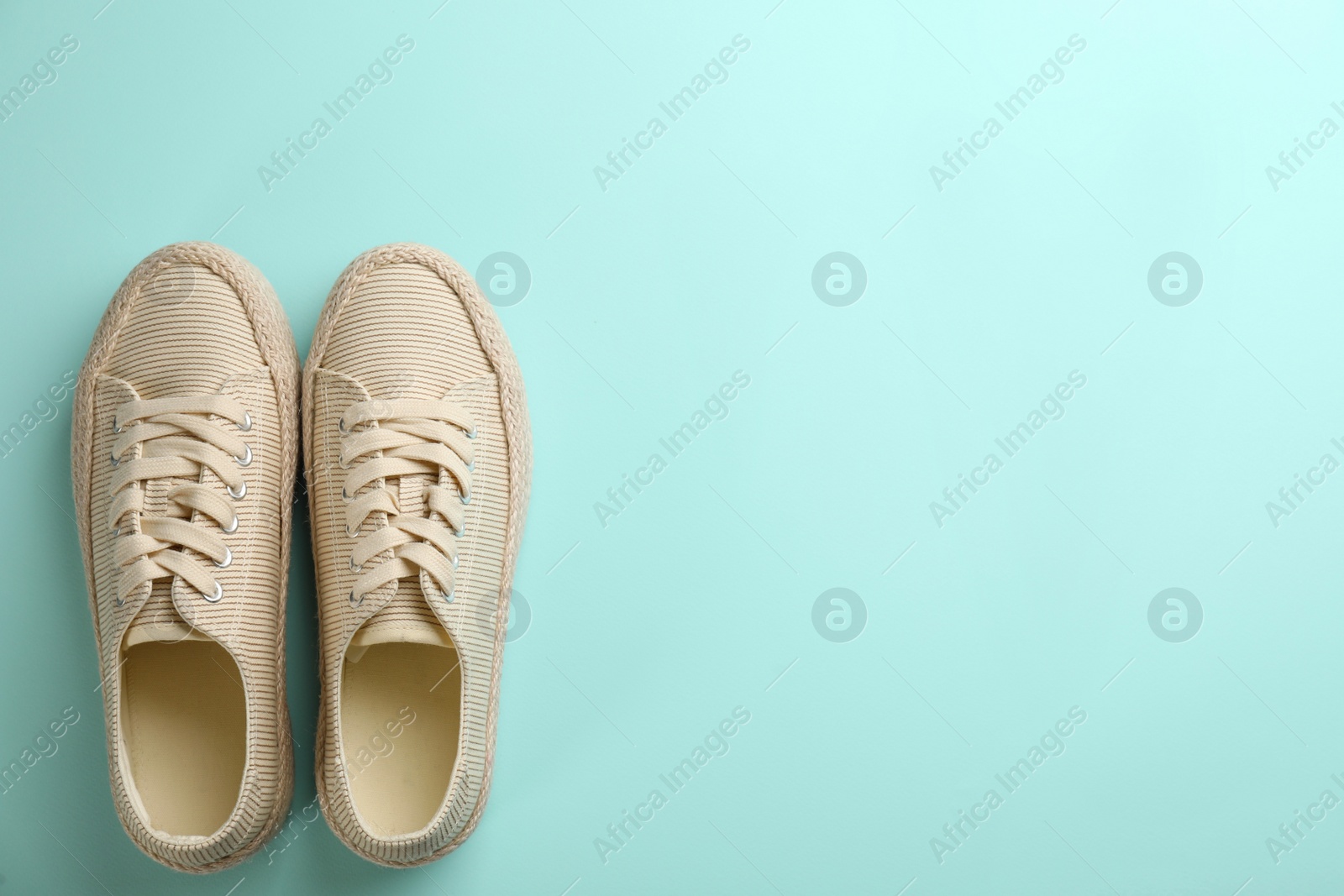 Photo of Pair of stylish comfortable shoes on turquoise background, flat lay. Space for text