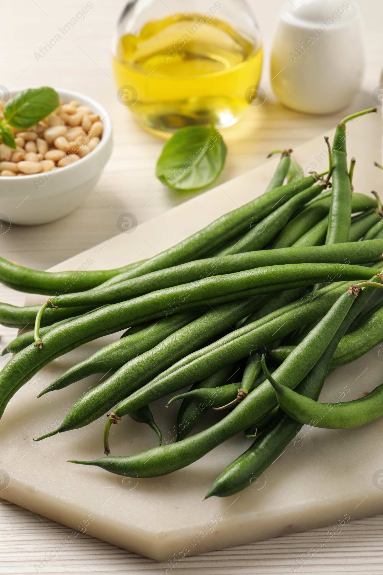 Photo of Board with fresh green beans on white wooden table