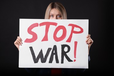 Woman holding poster with words Stop War on black background