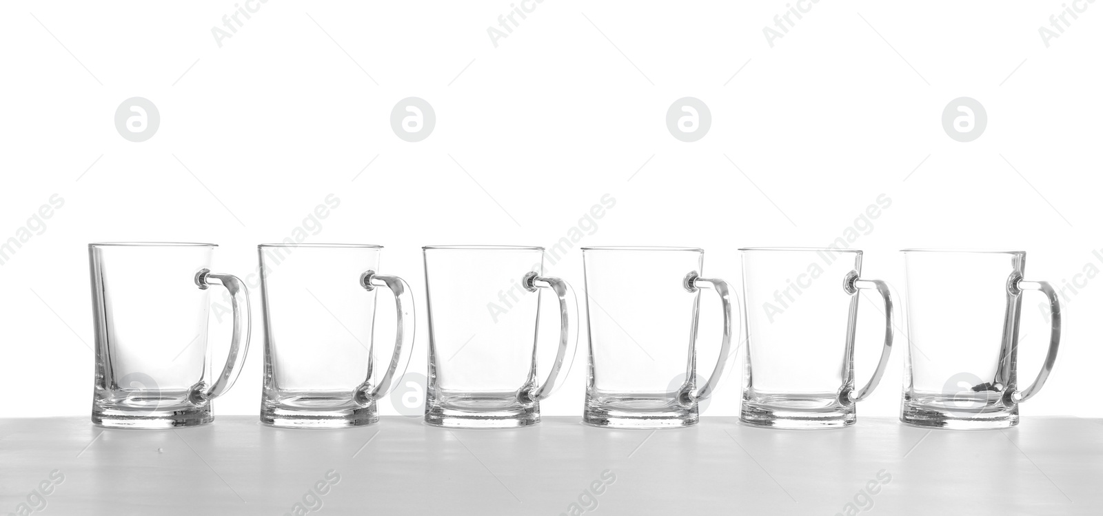 Photo of Row of empty beer mugs on white background