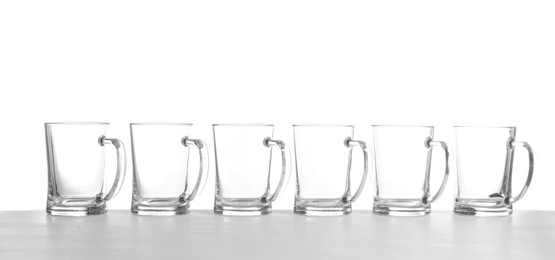 Photo of Row of empty beer mugs on white background