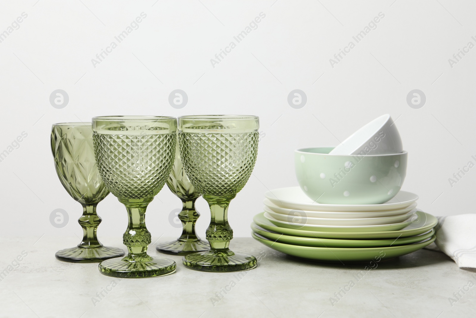 Photo of Beautiful ceramic dishware and glasses on light grey table