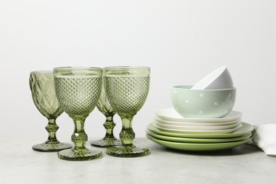 Beautiful ceramic dishware and glasses on light grey table