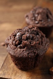Delicious chocolate muffin on wooden table, closeup