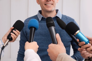 Photo of Happy business man giving interview to journalists at official event, closeup