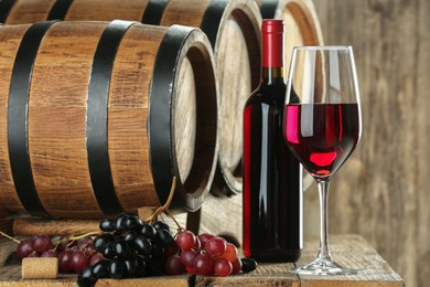 Winemaking. Composition with tasty wine and barrels on wooden table