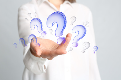 Image of Businesswoman on blue background demonstrating drawings of question mark