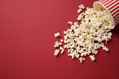 Photo of Delicious popcorn on red background. Space for text