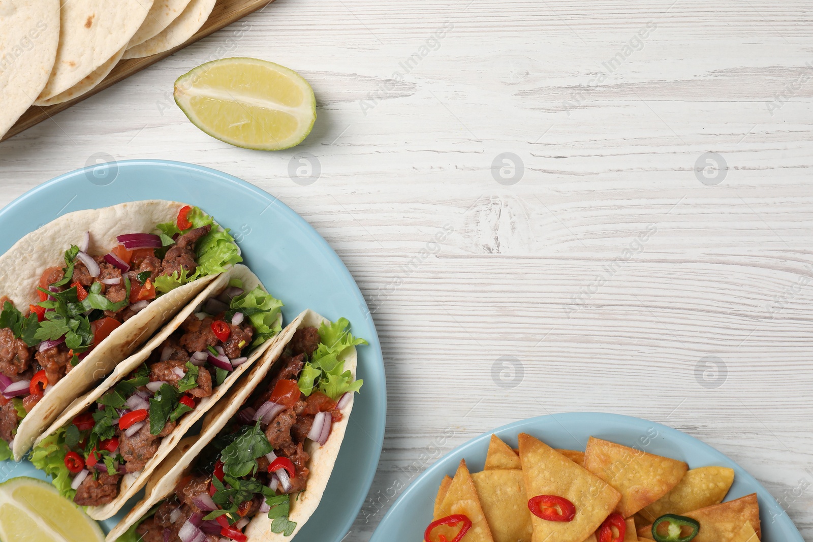 Photo of Flat lay composition with delicious tacos on wooden table, space for text