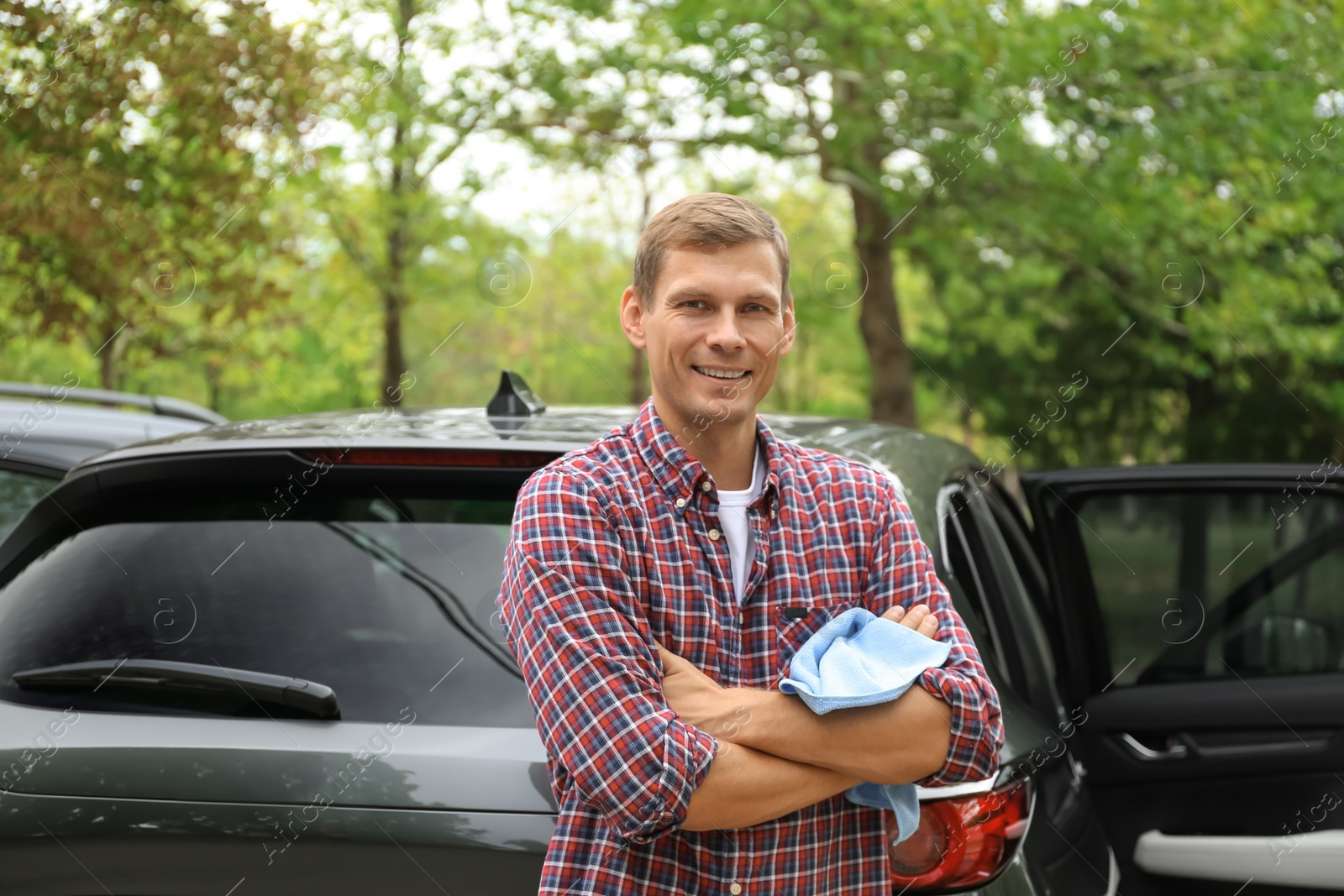 Photo of Man with rug near washed car outdoors