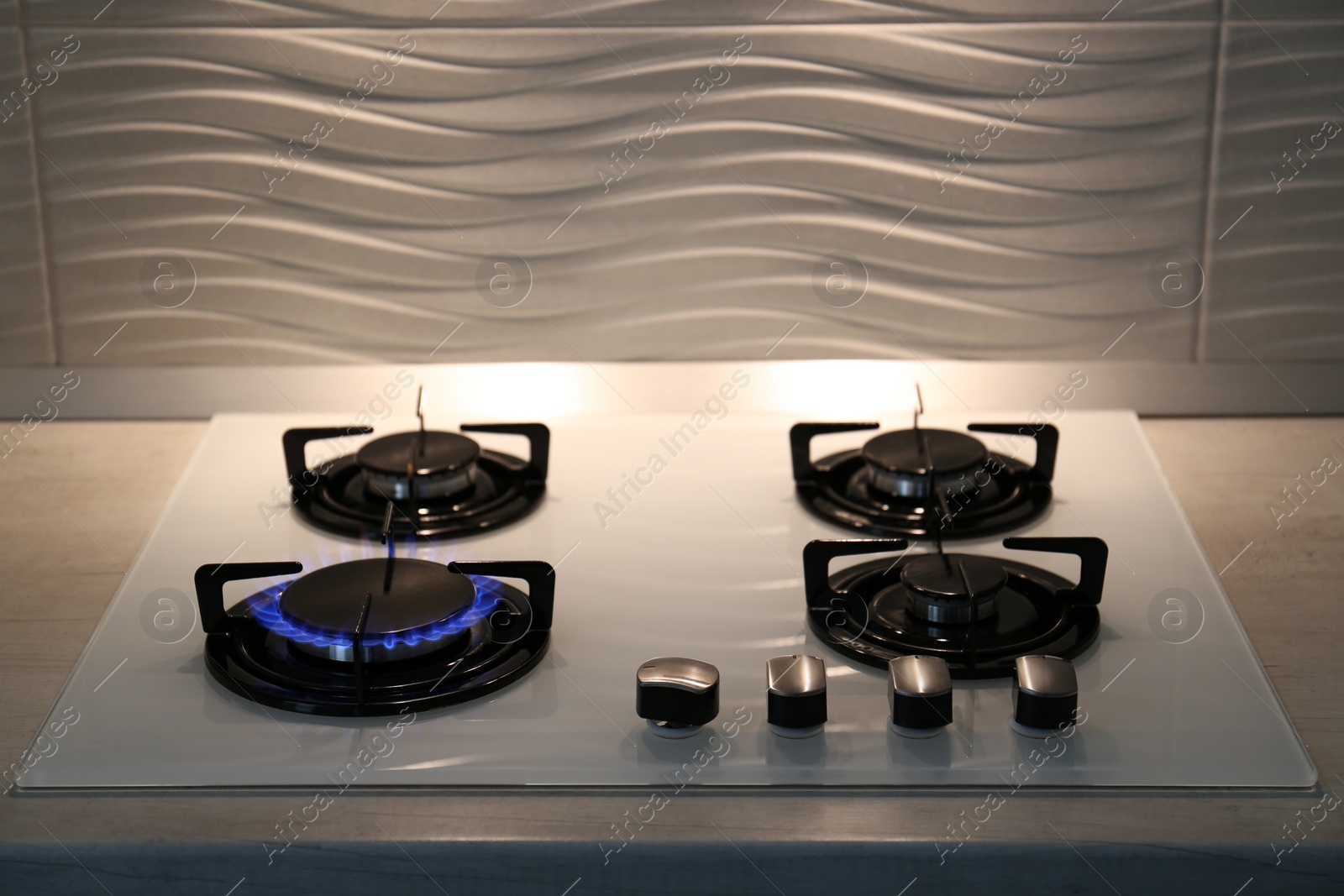 Photo of Modern kitchen stove with burning gas indoors