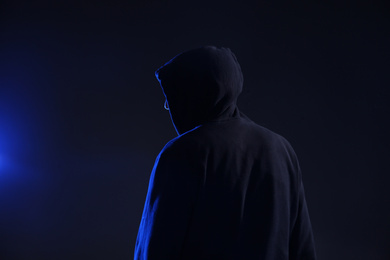 Photo of Man in hood on dark background. Cyber crime