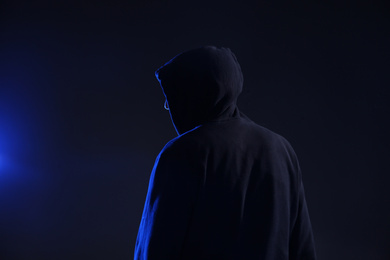 Man in hood on dark background. Cyber crime