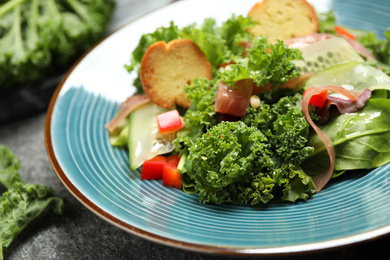 Photo of Delicious salad with kale leaves on table, closeup