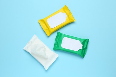 Photo of Wet wipes flow packs on light blue background, flat lay