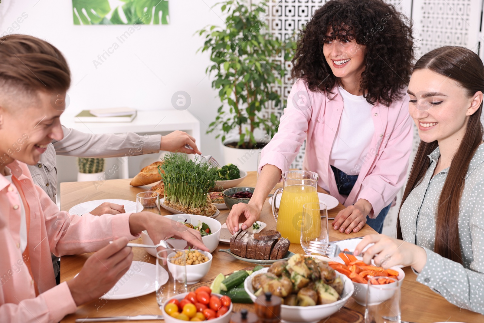 Photo of Friends eating vegetarian food at table indoors